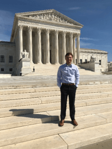 Paxton stands in front of the Supreme Court with his hands in his pockets.