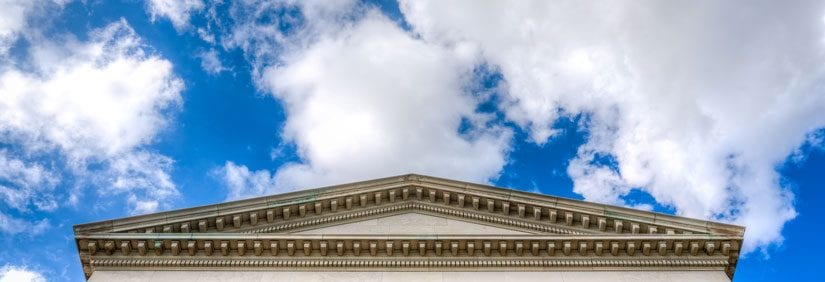 Big blue sky and fluffy clouds float behind the iconic Dallas Hall building.
