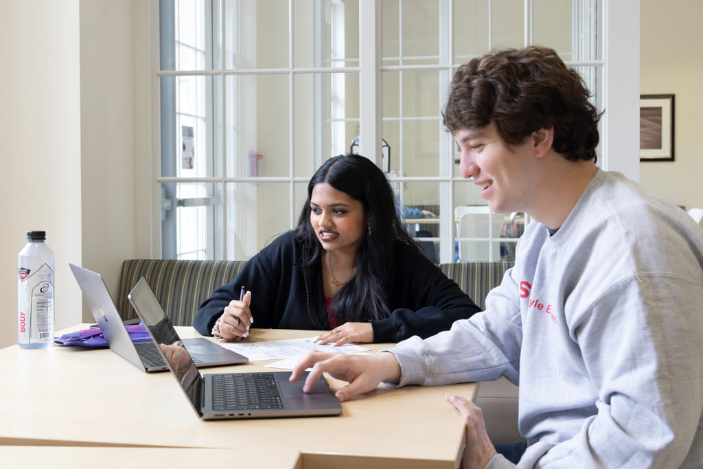 Two students looking at laptop computers